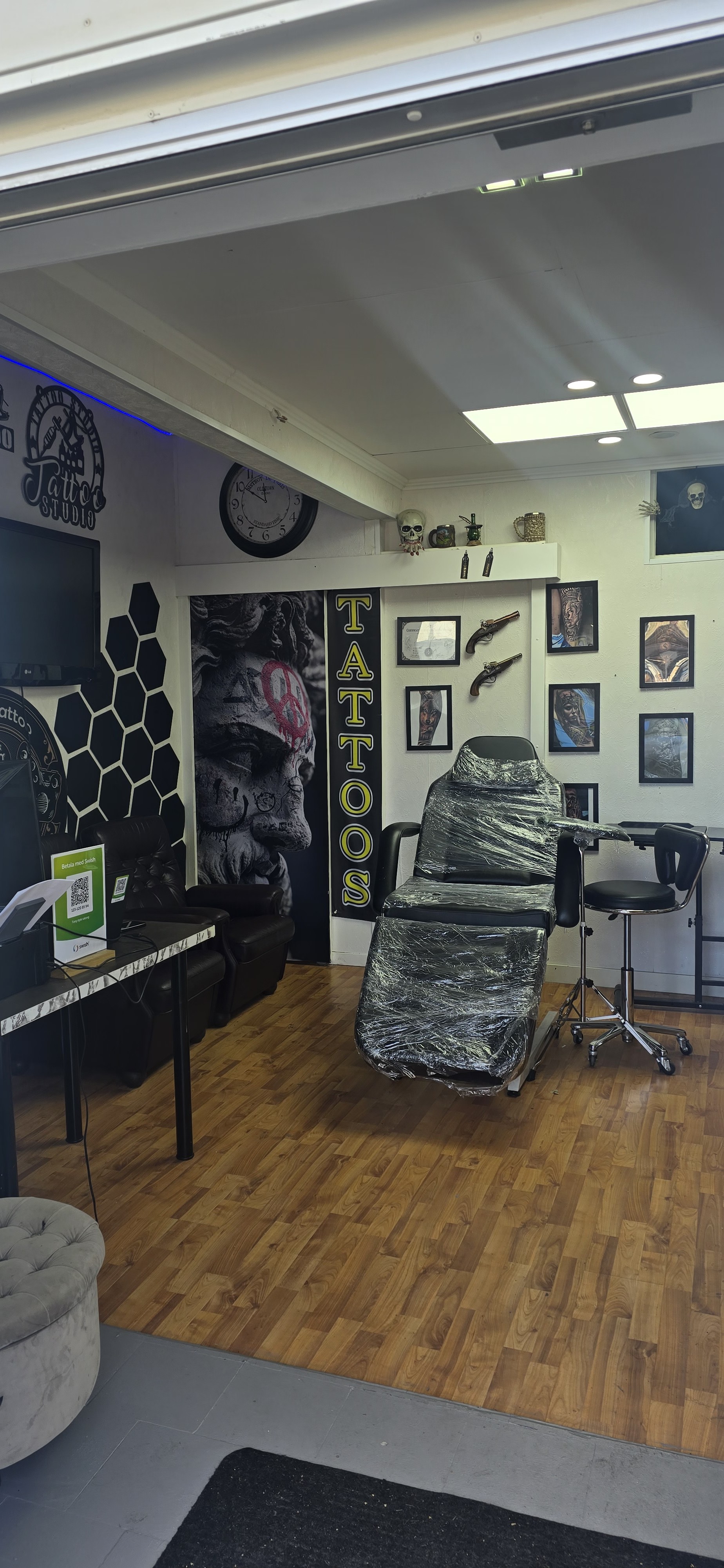 Tatueringsstudion hos Tony Style Salong med behandlingsstol och tatueringskonst på väggarna
