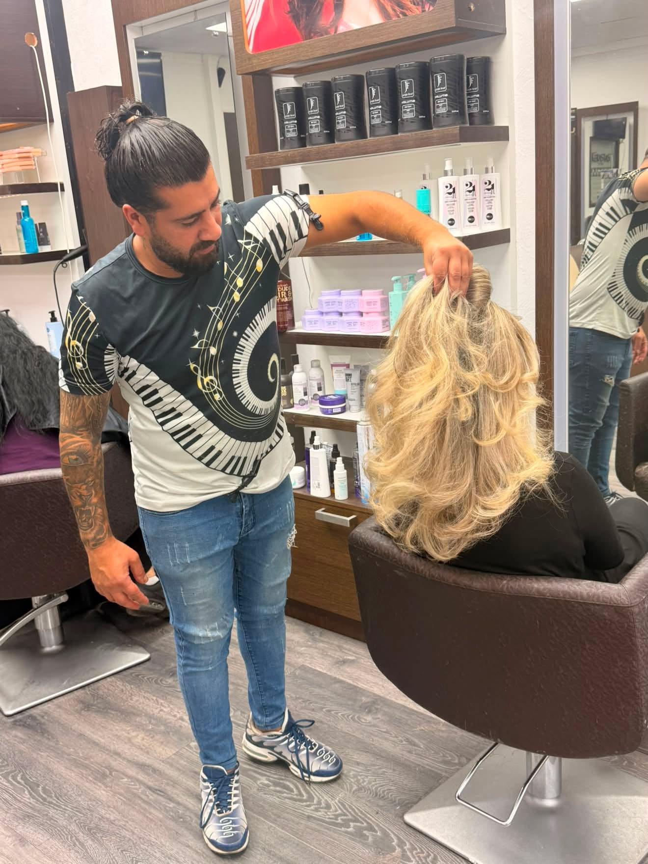 Frisör visar resultatet av blonda slingor med lockig styling